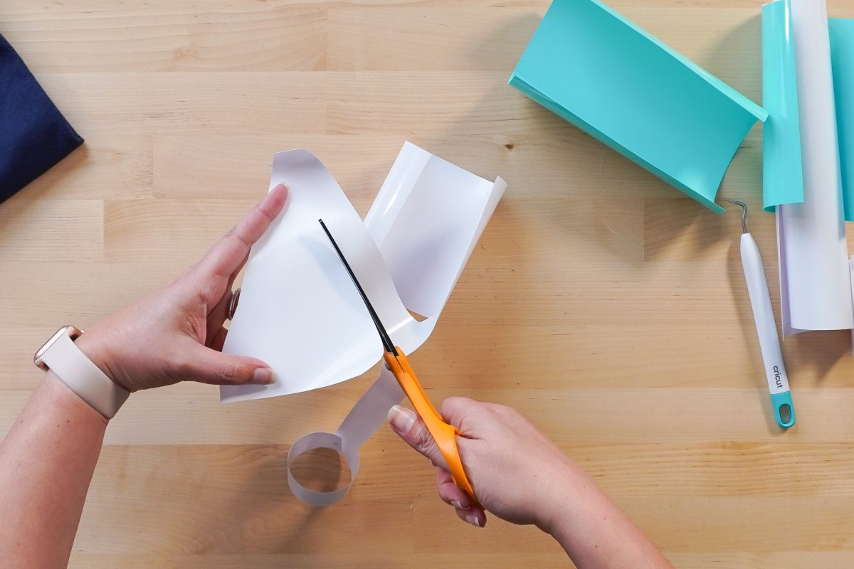 Hands cutting off excess vinyl