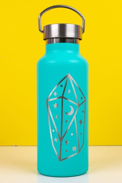 Aqua blue tumbler with a "magical" type of image etched out of the front