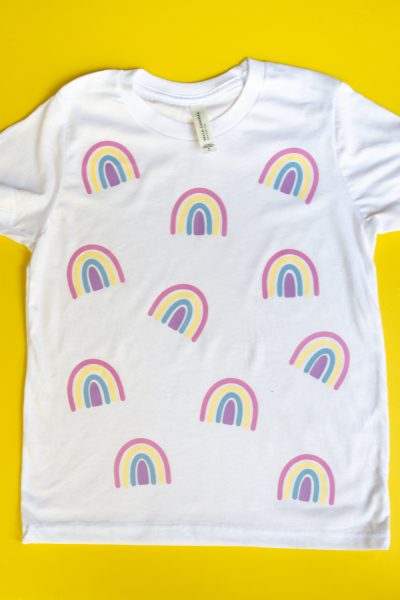 Rainbow-covered shirt on yellow background.