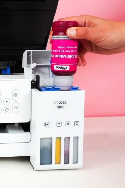 Hand holding magenta Hiipoo bottle and filling tank