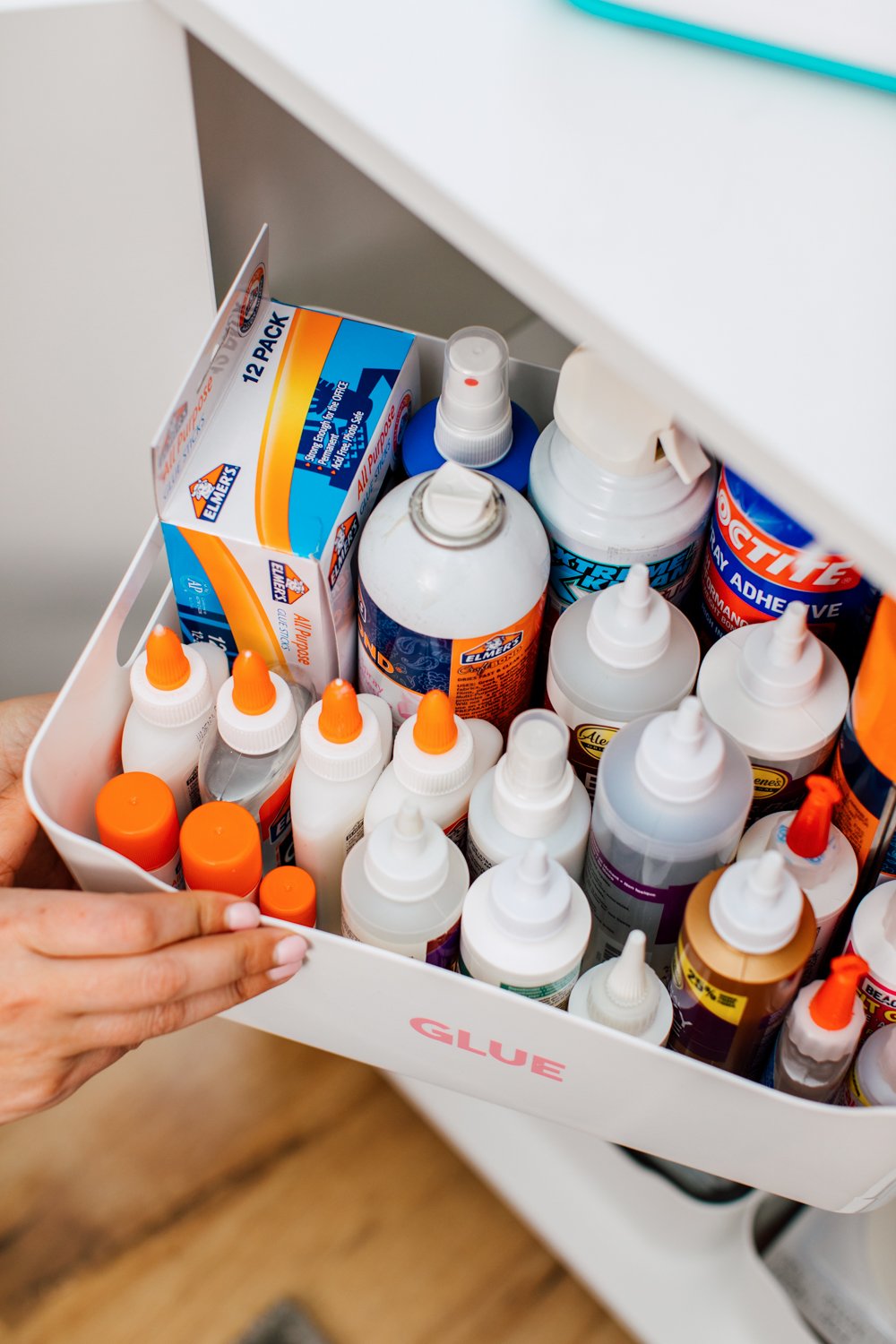 Hand pulling glue bin out of the cabinet