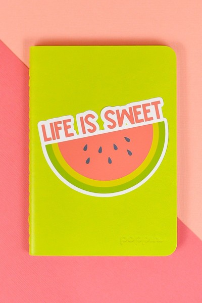 Life is Sweet watermelon sticker on green notebook on pink background