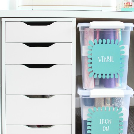 Vinyl storage bins sitting next to a small chest with drawers