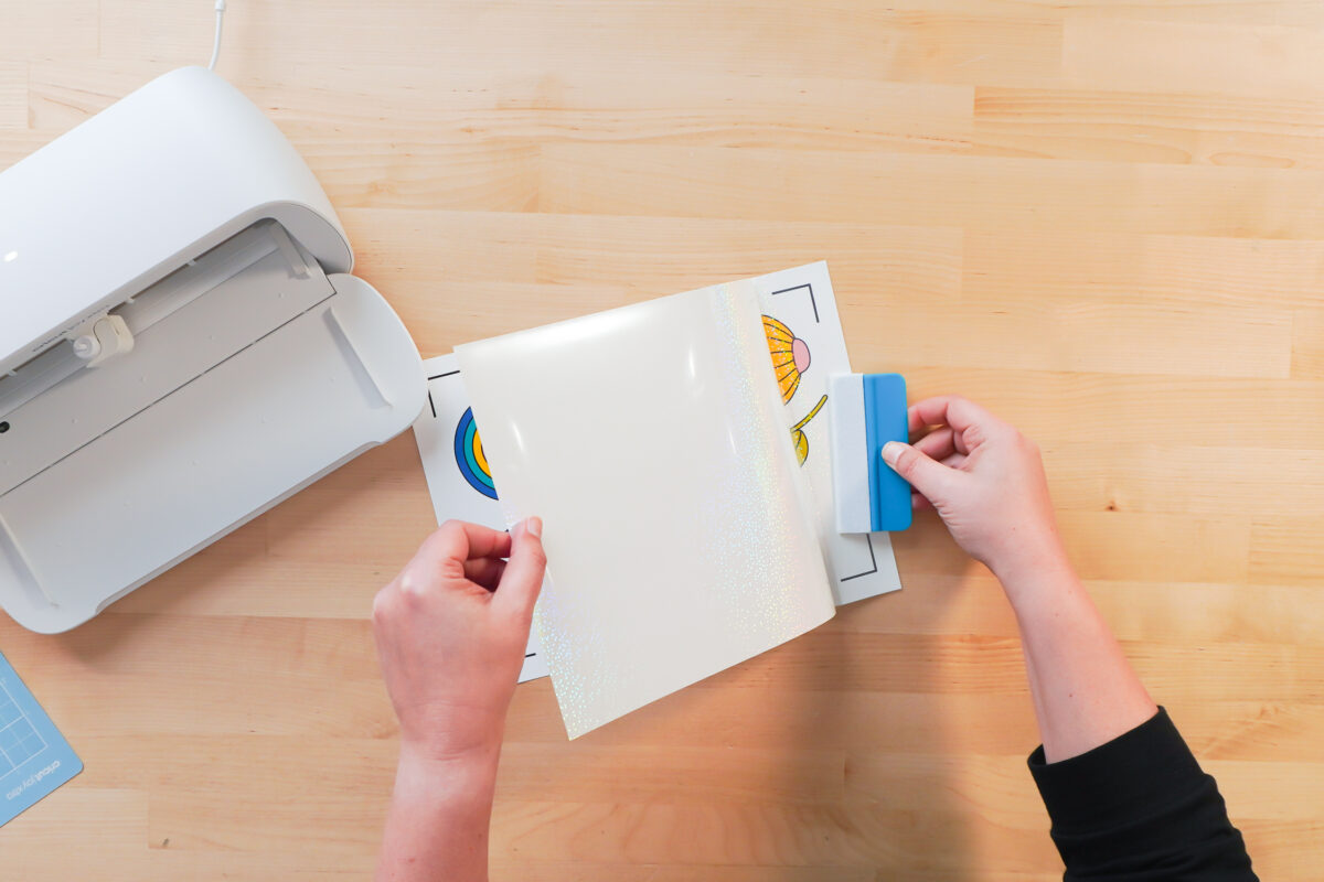 Hands using a squeegee to add the waterproof layer to the printed layer