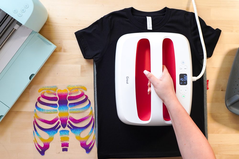 Hands pre-pressing the black t-shirt