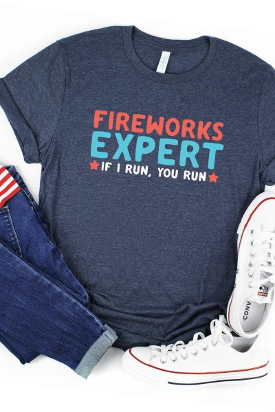 Blue Jeans, American flag, white tennis shoes and a gray t-shirt that says, Fireworks Expert, If I Run, You Run