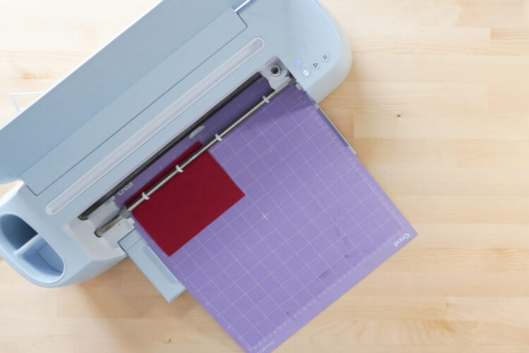 Faux leather on purple mat loaded into Cricut machine