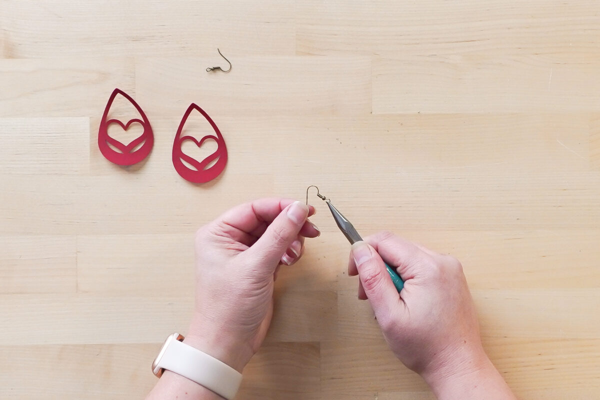 Showing process of putting the fish hook onto the earring