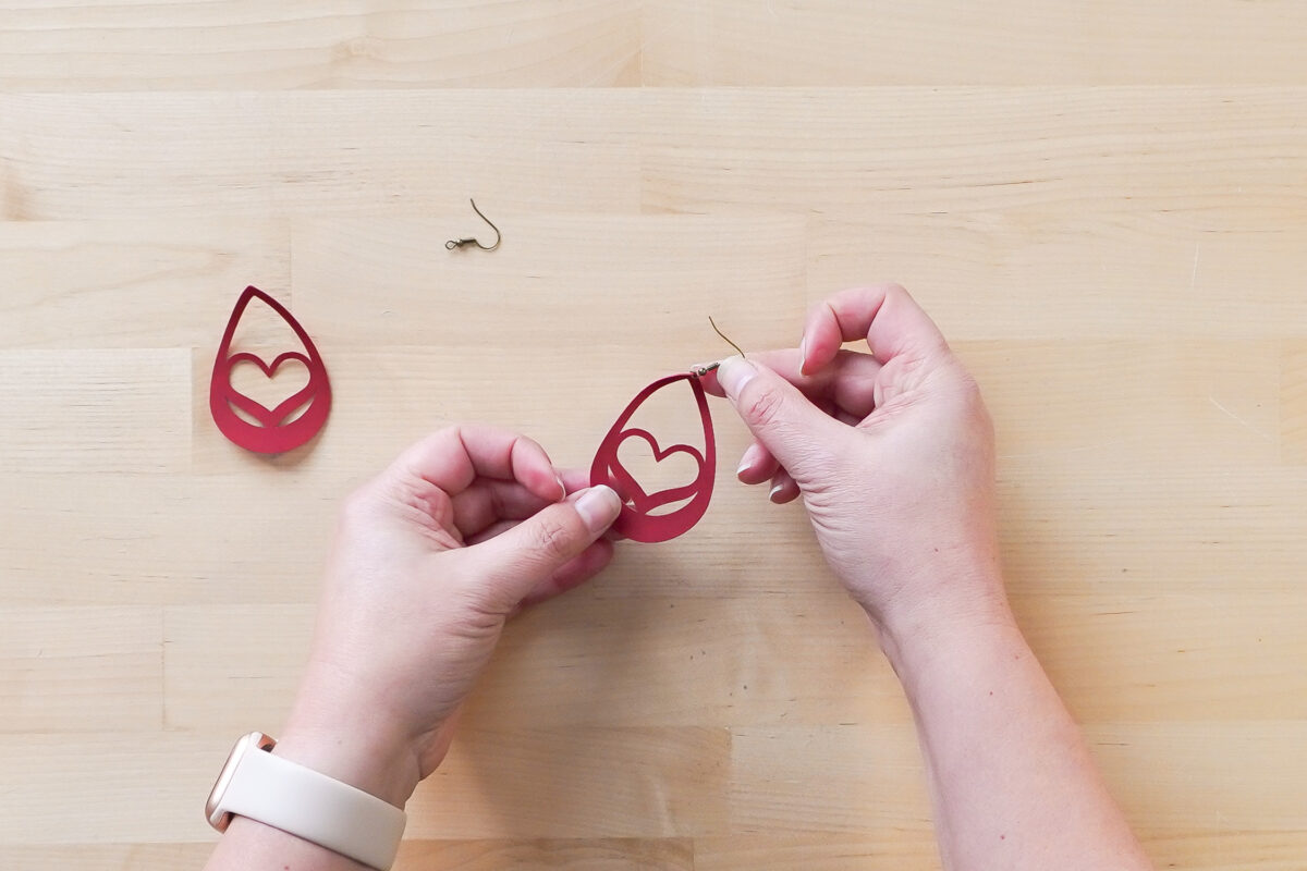 Showing process of putting the fish hook onto the earring