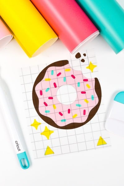 Final layered donut image with rolls of vinyl and Cricut tools.
