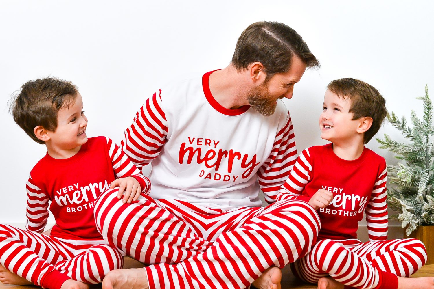 Boys wearing Very Merry Brother shirts and dad wearing Very Merry Daddy shirt