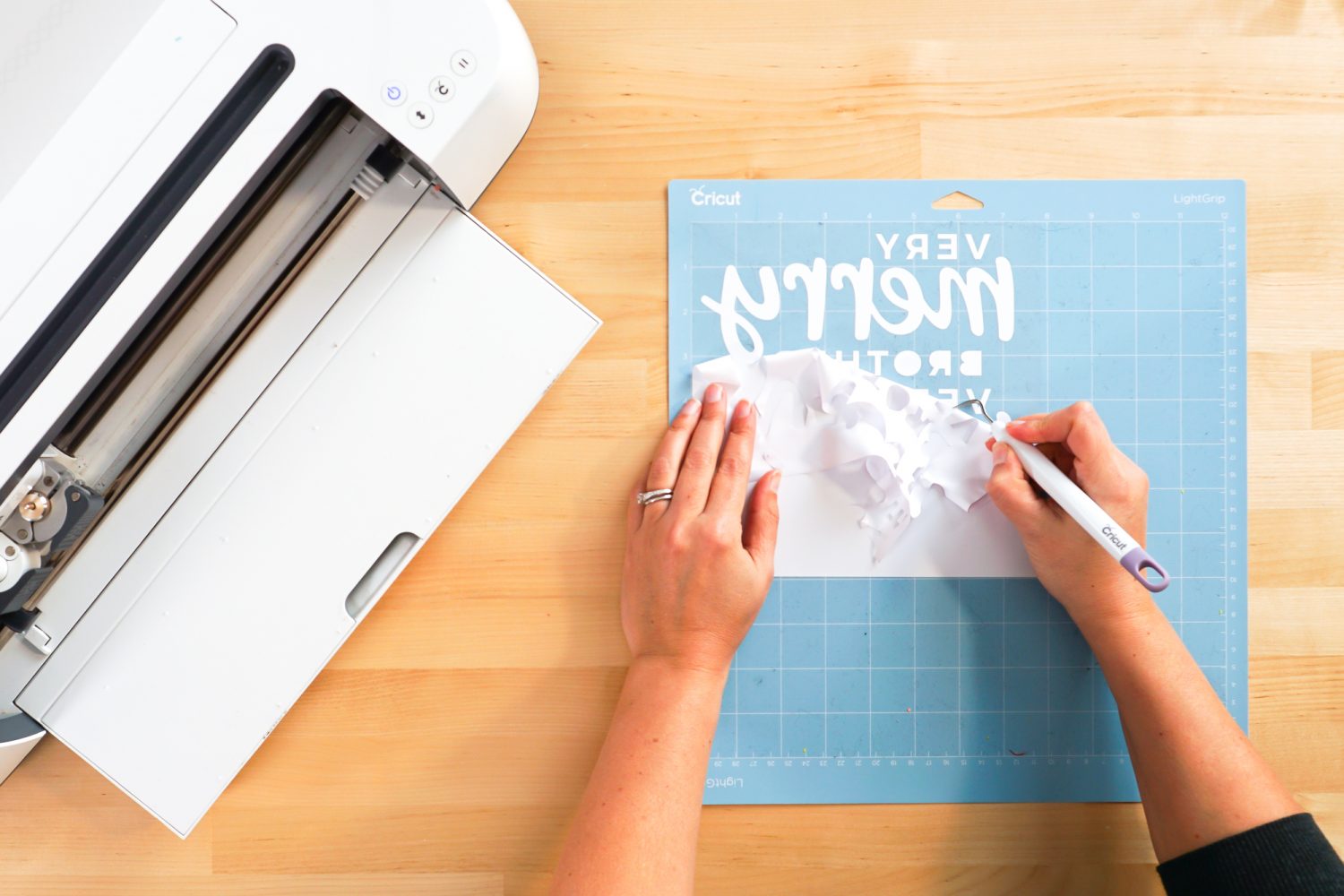 Hands weeding the iron on vinyl