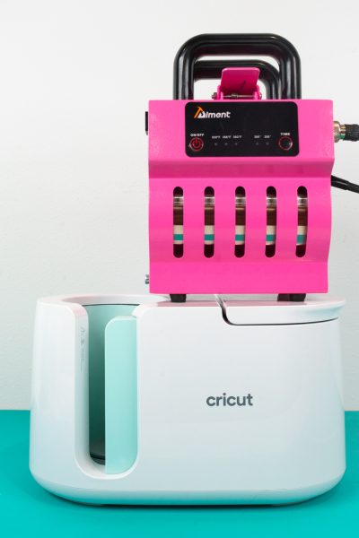 Cricut Mug Press and pink bargain press on a table