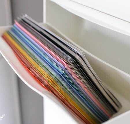 Scrapbook paper out of control? Use this IKEA Hack: Trones Shoe Holders are the perfect size and shape for holding all of your paper! Plus it takes up so little space in your craft room.