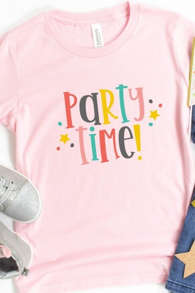 Tennis shoes, blue jeans and a pink t-shirt with the saying Party Time