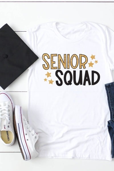 Graduation cap, blue jeans, white tennis shoes and a white t-shirt that says Senior Squad in black and gold lettering