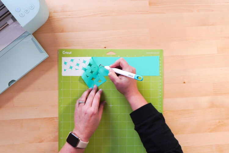 Hands weeding the stencil design