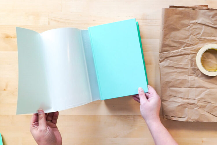 Hands removing the book cover