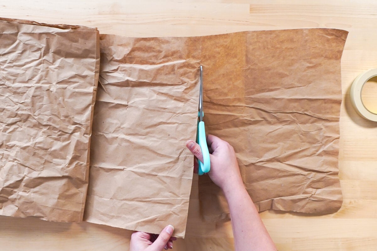 Hands wrapping the book in brown paper