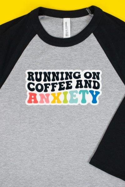"Running on Coffee and Anxiety" image on SubliFlock on gray and black baby tee