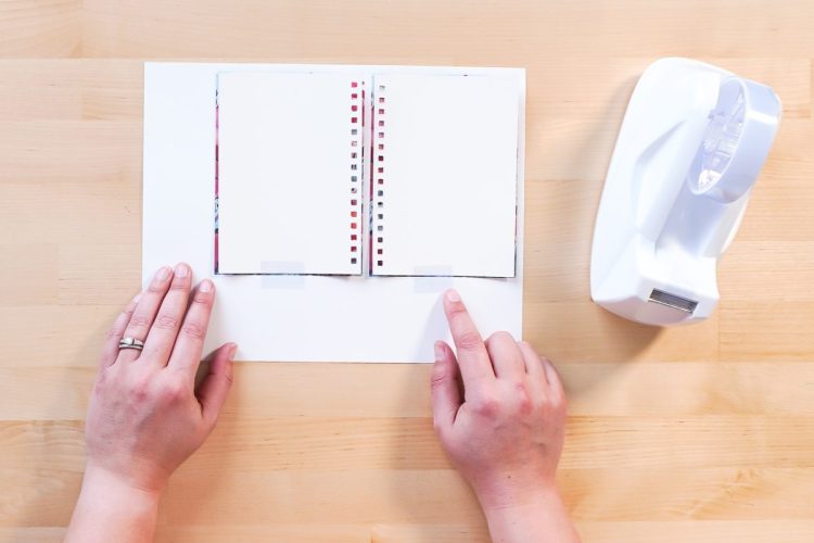 Hands taping sublimation designs to the journal covers