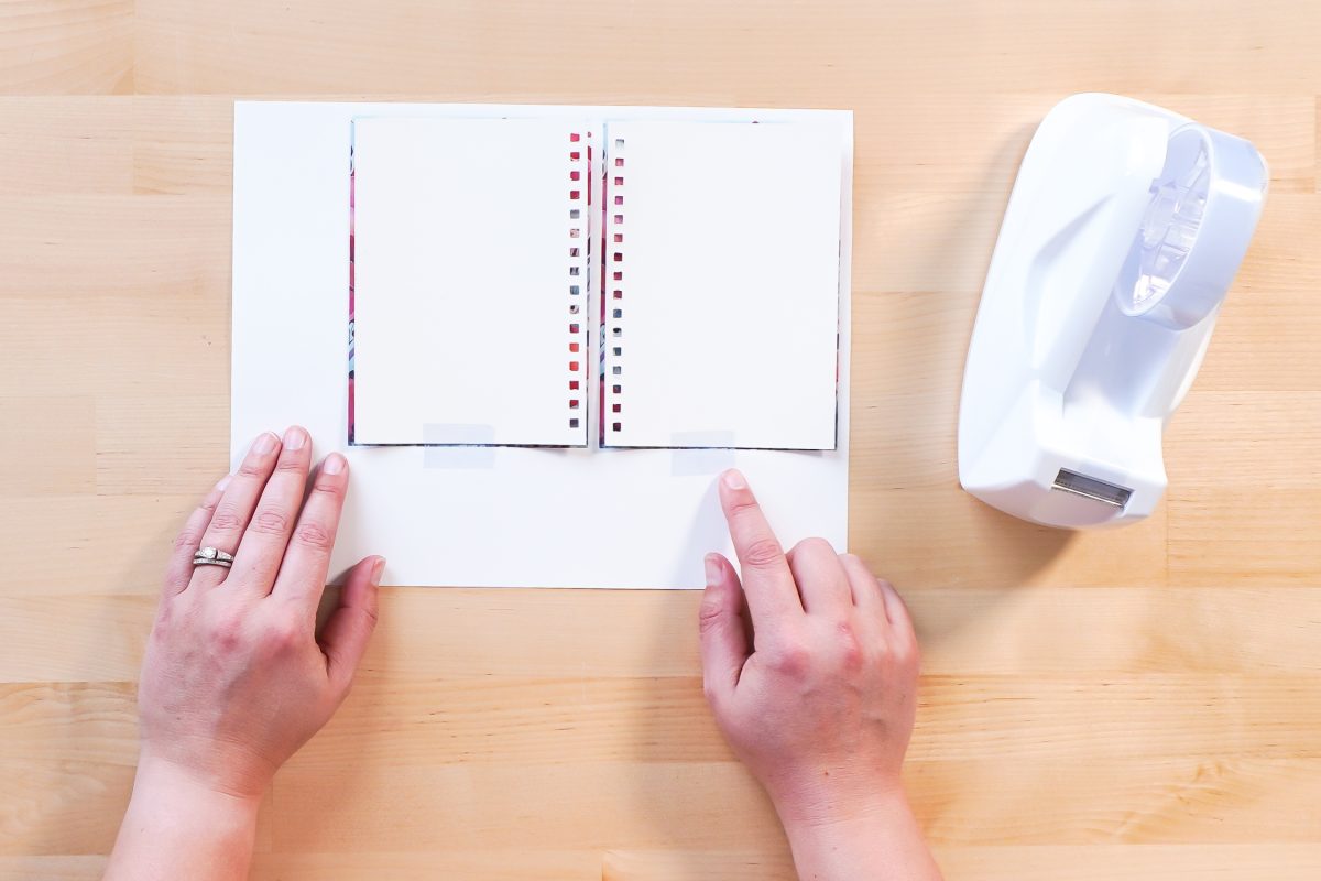Hands taping notebook covers to image