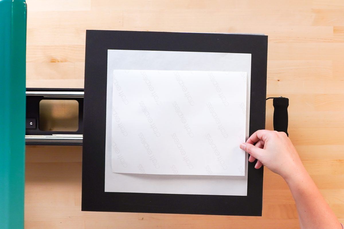 Hands placing the sublimation notebook in a heat press