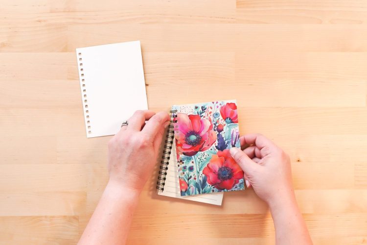 Hands putting the binding back onto a journal