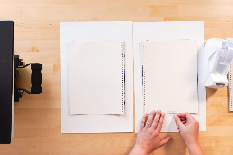 Hands taping journal cover to the sublimation design