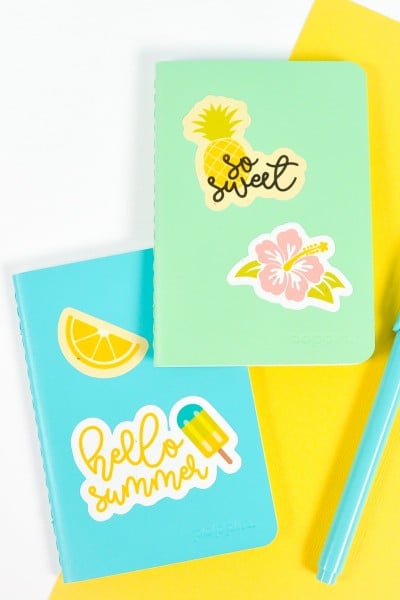 Blue and green notebooks with summer stickers on white and yellow background
