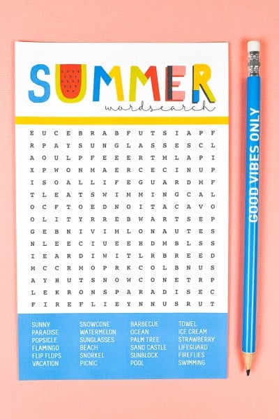 A blue pencil lying next to a Summer Word Search puzzle