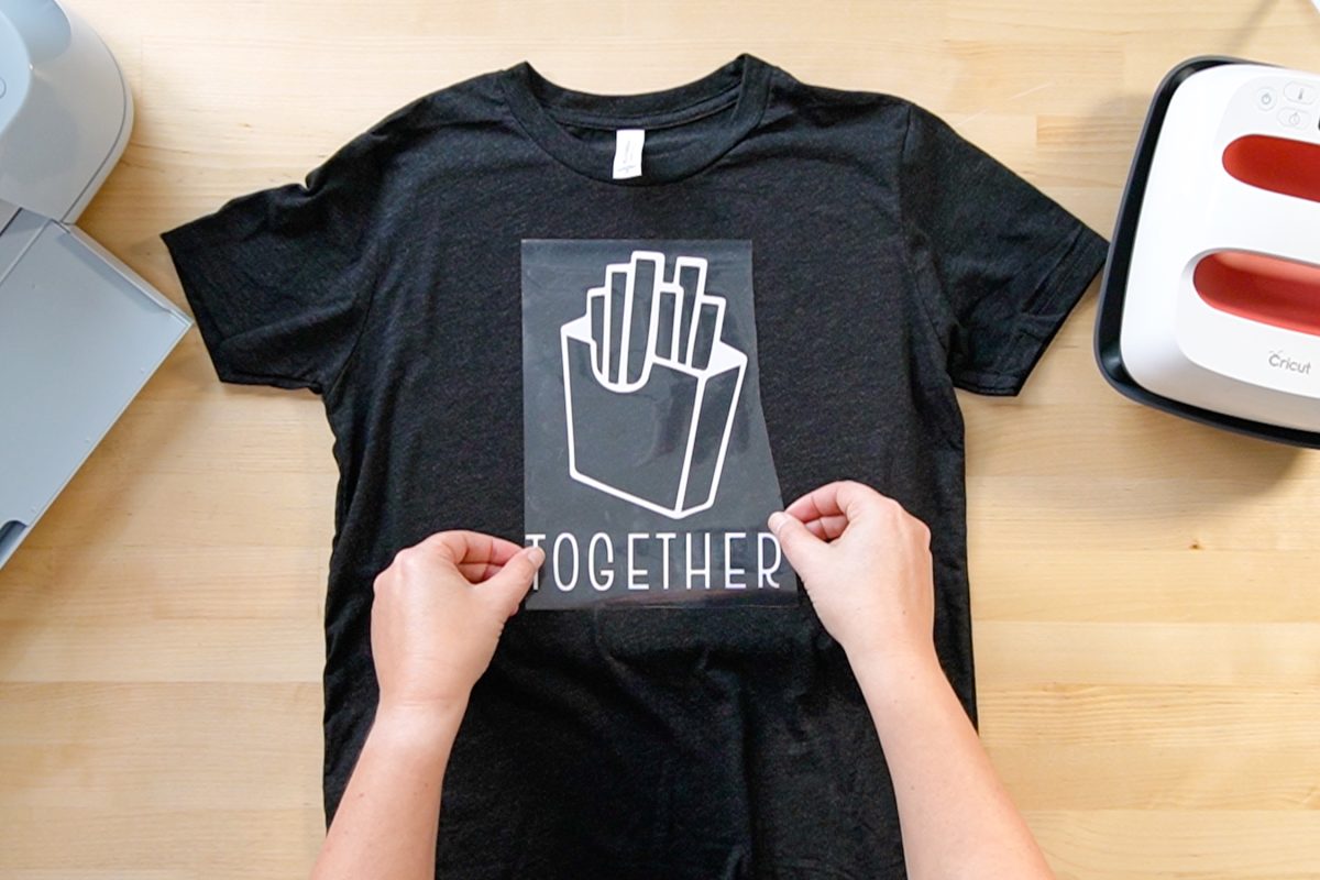 Hands placing decal on shirt