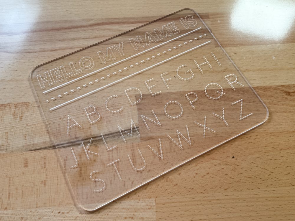 Clear acrylic engraved handwriting board on a desk