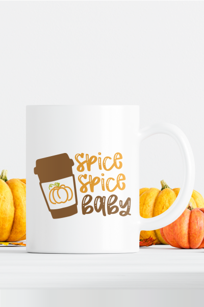 White mug sitting next to pumpkins and that has the saying Spice Spice Baby on it